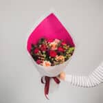 Bright red and pink floral bouquet with roses and berries. - The Village Florist Hunters Hill