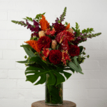 Red and orange floral arrangement with monstera - The Village Florist Hunters Hill